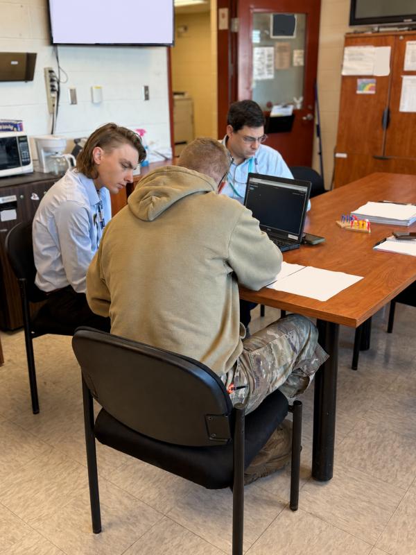 Working at a laptop with a U.S. Army service member